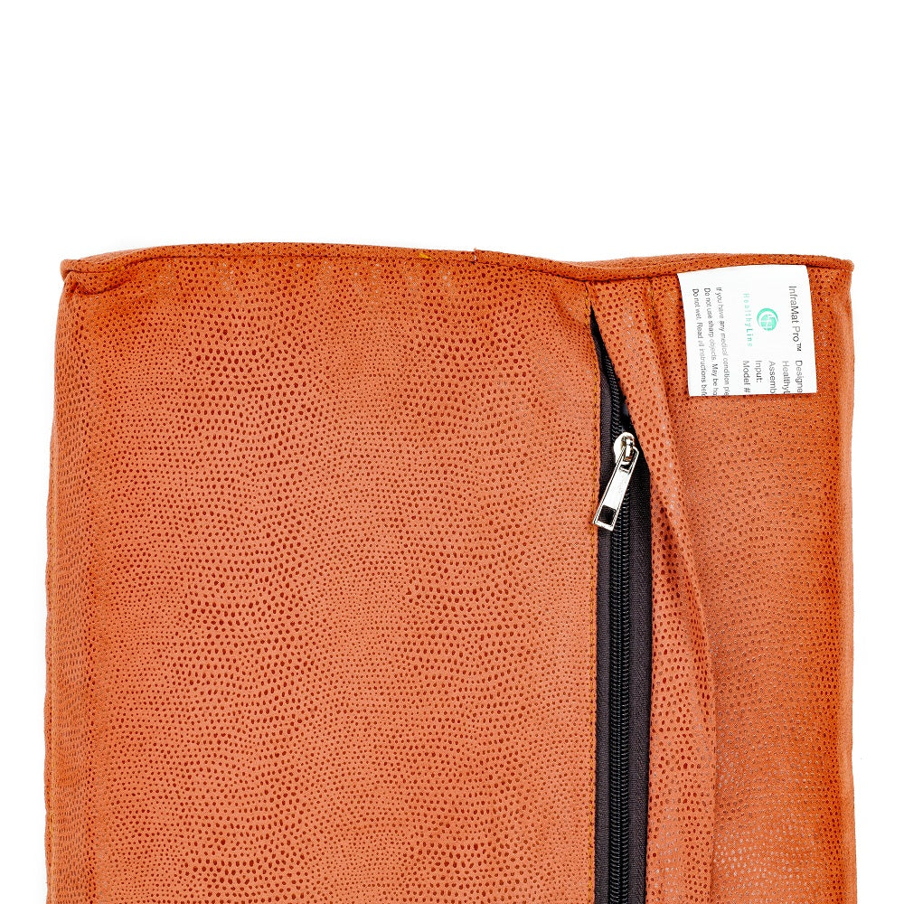 Close-up of the TAO-Mat® Pillow Soft InfraMat Pro® by HealthyLine shows a brown textured fabric with a black zipper on the right, partly open. A small white label with green text is near the zipper. The neck-supporting fabric features a subtle dotted pattern.