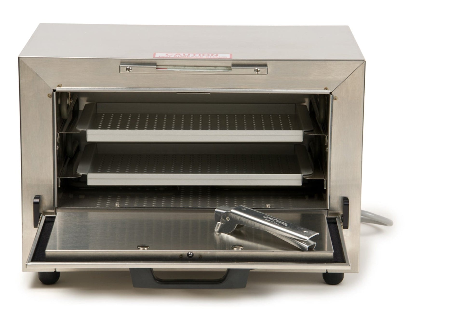 The Graham Field Stainless Steel Dry Heat Sterilizer, featuring two perforated racks inside, is perfect for sterilization purposes. With the front door open and a metal accessory placed on it, its sleek industrial design makes it suitable for both professional and home use while providing maintenance-free convenience to users.