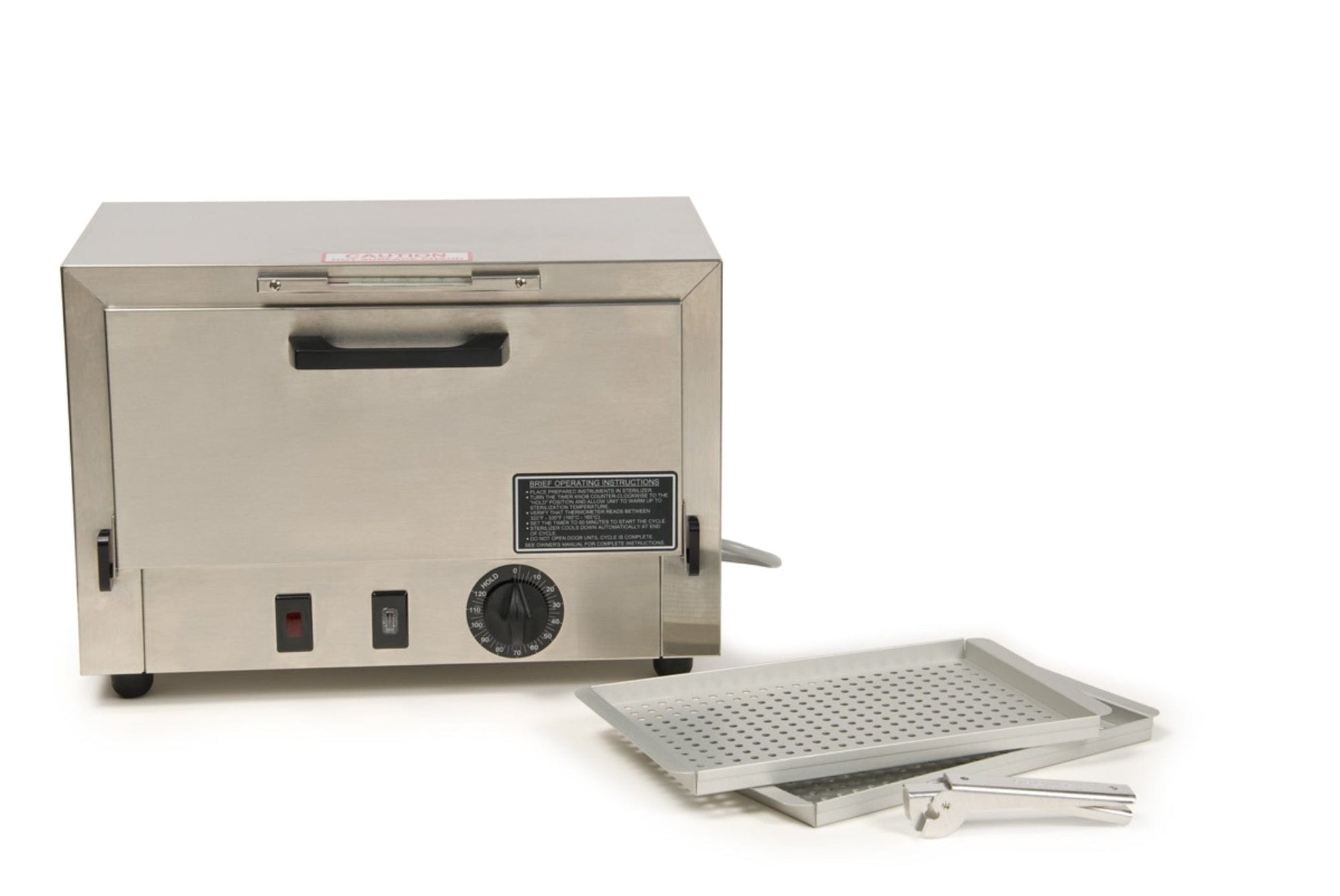 The image features the Graham Field Stainless Steel Dry Heat Sterilizer, equipped with a front handle and control knobs for maintenance-free operation. Accompanying it are a perforated metal tray and a pair of tongs, all set against a plain white backdrop.