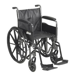 The Drive Medical Wheelchair K1/K2 20" Sport 2 features a black, durable steel frame, large rear wheels, small front casters, armrests, footrests, and a fabric seat and backrest. The "Drive" logo is visible on the side.