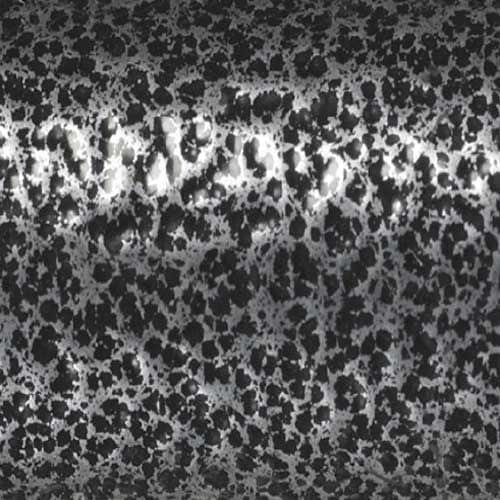 A close-up of a black and white speckled surface with irregular dark spots, resembling the textured frame finish found on the Drive Medical Silver Sport 2 Wheelchair, with subtle center highlights.