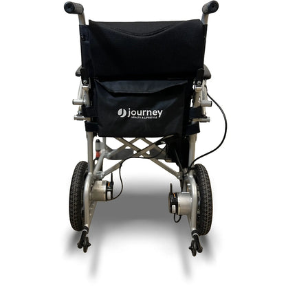 Rear view of the Journey Air Power Wheelchair by Journey Health & Life Style, a black and silver foldable model with large rear wheels, small front wheels, and a black storage pouch on the backrest.