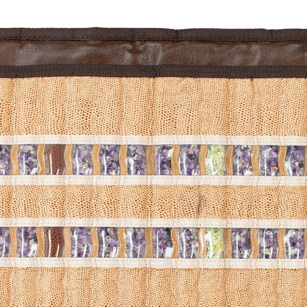 Close-up of a HealthLine SOFT-Mat™ Full 7224 InfraMat Pro®, featuring a textured fabric mat adorned with two horizontal rows of semi-precious stones, including amethyst and green stones. These gemstones are set against a beige woven base with intricate patterns, framed by a brown border for full body therapy.