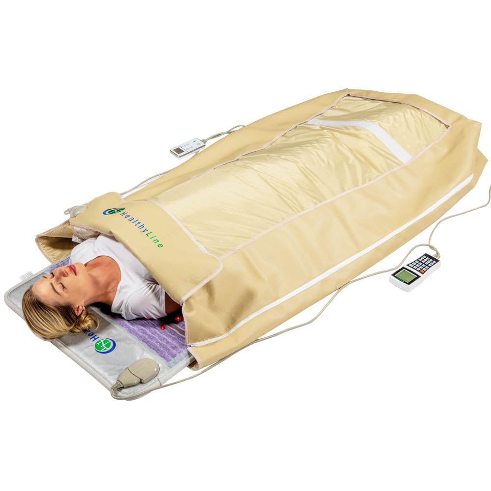 A person relaxes in a beige infrared sauna blanket from the HealthyLine 360 Wrap Set™ Platinum & SOFT Full Pro PLUS 7428, head exposed to enjoy soothing effects. The remote ensures a full-body experience enhanced by Photon Advanced PEMF InfraMat Pro®'s gemstone technology.