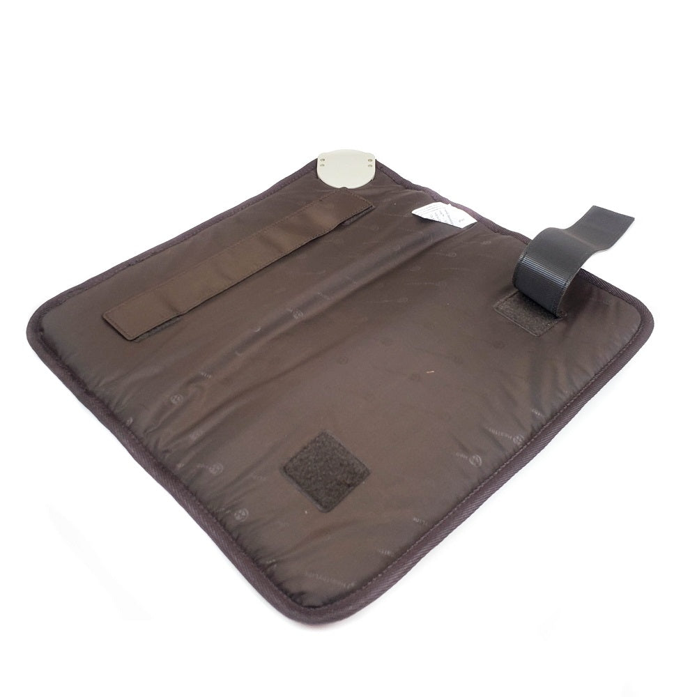 The TAO-Mat® Small 1818 Soft InfraMat Pro® by HealthLine, in a rich dark brown color, features a padded design with an adjustable strap and Velcro patches. A small metal plate accents the edge, while the surface displays a subtle dotted pattern infused with crushed natural gemstones for enhanced heat therapy benefits.