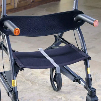 A close-up of the black Journey Health & Life Style UpWalker H200 Standard Large rollator, with multi-terrain wheels, padded armrests, safety strap, and a fabric seat—ideal for mobility support. Pictured indoors on a light-colored floor.