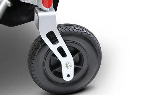 A close-up of the textured black rubber wheel attached to a metallic bracket, adorned with cut-out shapes, connects seamlessly to the EW-M45 Portable Power Wheelchair by E-Wheels. This red and black power wheelchair is set against a white background, showcasing its robust yet sleek design for effortless mobility.