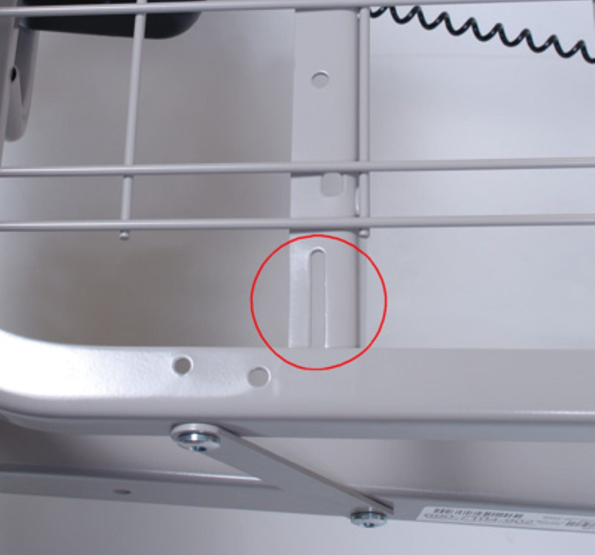 A close-up of a metal frame with a red circle highlighting a vertical notch in the support structure, reminiscent of the grid sleep surface seen in Graham Field's Patriot Homecare Beds, Semi-Electric. The frame’s wire grid elements are integral to this mechanical assembly, proudly MADE IN THE USA.