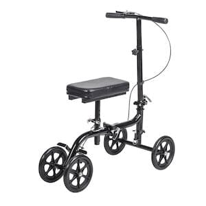 The Drive Medical Knee Walker Economy Folding RTL BX is a black knee walker with four wheels, padded knee rest, handlebars, and hand brake, offering support and mobility during leg injury recovery.