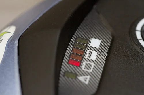 Close-up of the EW-M39 Power Scooter by E-Wheels featuring a wireless mobility indicator with five colored lights, including red and green, plus various symbols. The design complements a textured, segmented pattern in the black-framed background.