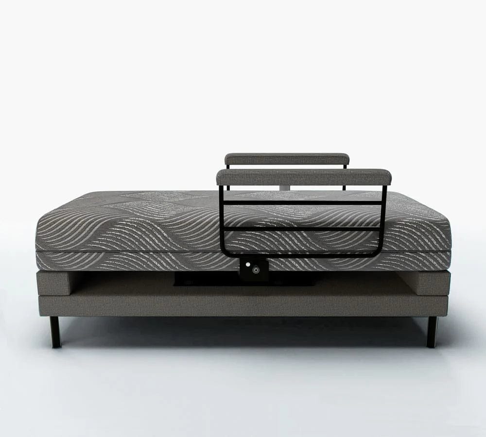 A contemporary lift bed by Journey Health & Lifestyle, the Upbed Independence includes a memory foam mattress with a patterned design and an elevated headrest support. It showcases minimalist elements and a durable metal frame, set against a plain, light-colored wall.